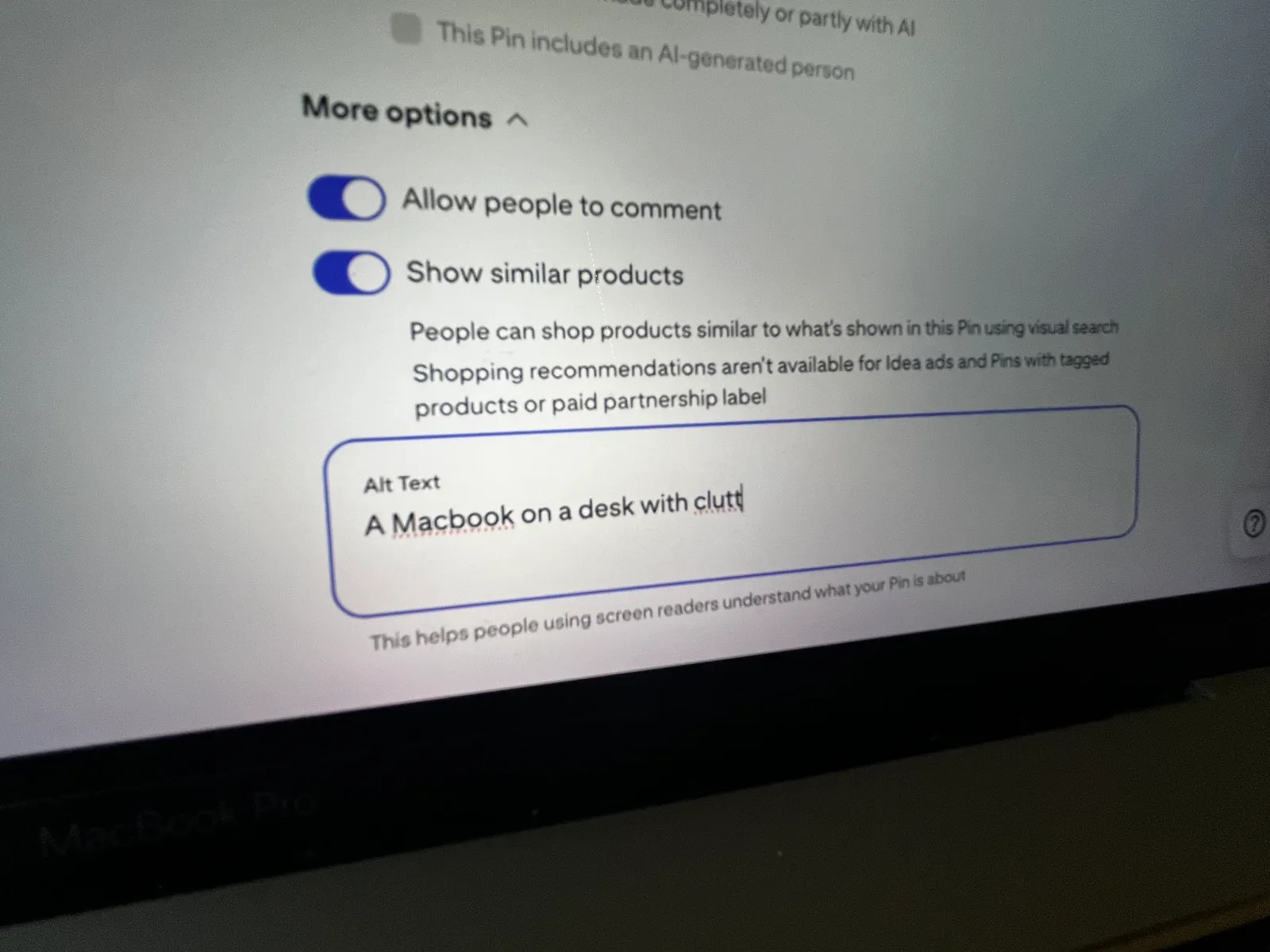 Pinterest Edit Pin screen showing "More options" with toggles for "Allow people to comment" and "Show similar products" both enabled. An alt text field is highlighted containing the description "A Macbook on a desk with clutter." Below it states this helps people using screen readers understand what the pin is about.